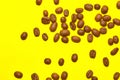 Coffee beans isolated on the yellow background. Joyful coffee-theme Royalty Free Stock Photo