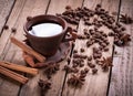 Coffee grinder and hot cup of coffee on wooden table