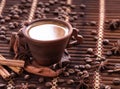 Coffee grinder and hot cup of coffee on wooden table