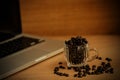 Coffee beans and laptob on wood background and texture. Royalty Free Stock Photo