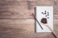 Coffee beans and and lined paper on wooden table top view Royalty Free Stock Photo