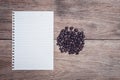 Coffee beans and and lined paper on wooden table top view Royalty Free Stock Photo