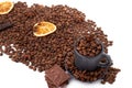 Coffee beans, pieces of chocolate, dried orange slice and a cup with coffee beans