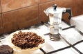 Coffee beans on a plate and moka coffe pot on a gas stove Royalty Free Stock Photo