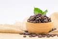 Coffee beans roasted in a wooden bowl on sackcloth over white background Royalty Free Stock Photo