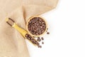 Coffee beans roasted in a wooden bowl and beans scoop on sackcloth over white background. Top view Royalty Free Stock Photo