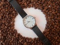 Coffee beans are scattered on the table space for text in the form of a circle, hand watch. Coffee time concept Royalty Free Stock Photo