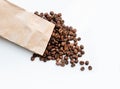 Coffee beans are scattered on a white background. coffee with a paper bag. coffee and the environment. Royalty Free Stock Photo
