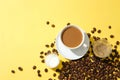 Coffee beans scattered on a yellow background. A glass of milk coffee, a glass of black coffee and a glass of milk are placed next