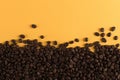Coffee beans are scattered on a yellow paper background close-up, concept, commercial copy space Royalty Free Stock Photo