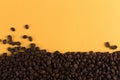 Coffee beans are scattered on a yellow paper background close-up, concept, commercial copy space Royalty Free Stock Photo