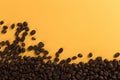 Coffee beans are scattered on a yellow paper background close-up, concept, commercial copy space Royalty Free Stock Photo