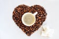 Coffee beans in the shape of a heart and a cup of freshly brewed coffee. Background from coffee Valentine`s Day. Royalty Free Stock Photo