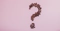 The coffee beans in shape of question mark, isolated on pink background Royalty Free Stock Photo