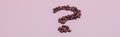 The coffee beans in shape of question mark, isolated on pink background Royalty Free Stock Photo