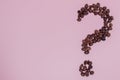The coffee beans in shape of question mark, isolated on pink background Royalty Free Stock Photo