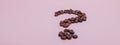 The coffee beans in shape of question mark, isolated on pink background Royalty Free Stock Photo