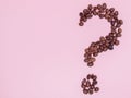 The coffee beans in shape of question mark, isolated on pink background Royalty Free Stock Photo