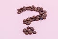 The coffee beans in shape of question mark, isolated on pink background Royalty Free Stock Photo