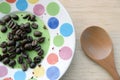 Coffee beans in small plate and ground coffee in wooden spoon Royalty Free Stock Photo