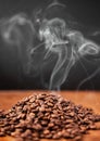 Coffee beans, smoke and table closeup in studio isolated on a black background or backdrop. Steam, caffeine and aroma of Royalty Free Stock Photo