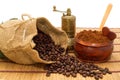 Coffee beans spilled out of the bag, ground coffee in a bowl, spoon, little heart and coffee grinder