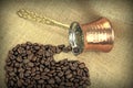 Coffee beans spilled from traditional Turkish copper coffee pot on a burlap Royalty Free Stock Photo