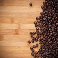 Coffee Beans spilling on to a wooden benchtop Royalty Free Stock Photo