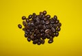 coffee beans sprinkled on a yellow background, top view