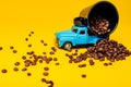 Coffee beans and a toy car on a yellow background. Royalty Free Stock Photo