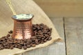 Coffee beans and traditional Turkish copper coffee pot on a burlap Royalty Free Stock Photo