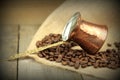 Coffee beans and traditional Turkish copper coffee pot on a burlap Royalty Free Stock Photo