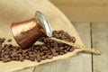 Coffee beans and traditional Turkish copper coffee pot on a burlap Royalty Free Stock Photo