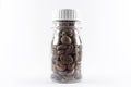Coffee beans in transparent bottle isolated white background. Caffeine beverage symbol