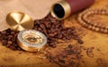 Coffee Beans and Vintage Compass with  magnifying glasson an old world map - trade and explorer concept Royalty Free Stock Photo