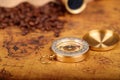 Coffee Beans and Vintage Compass with  magnifying glasson an old world map - trade and explorer concept Royalty Free Stock Photo