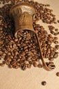 Coffee beans and vintage copper turkish coffee pot (cezve or ibrik) on the cloth sack