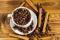 Coffee beans in white cup, cinnamon sticks and star anise on wooden table. Top  view Royalty Free Stock Photo