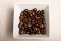 Coffee beans in a white dish on a white wood background shot from above Royalty Free Stock Photo