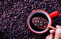 Coffee beans on wooden spoon over a red cup with black coffee in top view style Royalty Free Stock Photo