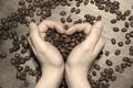 Coffee beans in your palms. Hands making a heart shape.