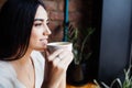 Coffee. Beautiful Girl Drinking Tea or Coffee in Cafe. Beauty Model Woman with the Cup of Hot Beverage. Royalty Free Stock Photo