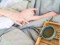 Coffee in bed. shapely female legs in warm socks, wooden tray for breakfast in bed. two cups of coffee and marshmallows