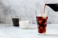 Coffee Being Poured into Tall Glass with Ice on Light Grey Background. Concept Refreshing Summer Drink Royalty Free Stock Photo