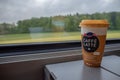 Coffee in big cup for take away on steel table in train on beautiful view background