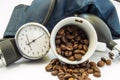 Coffee and blood pressure. Cup with coffee beans inside, surrounded by cuff and sphygmomanometer for measuring blood pressure. Con