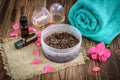 Coffee body scrub, sugar and coconut oil, essential oils, massage vacuum jars on dark wooden rustic table with pink flowers Royalty Free Stock Photo