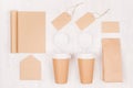 Coffee branding identity mockup - set of two brown paper cups with blank notebook, label, card, cap, envelope, packet on wood. Royalty Free Stock Photo