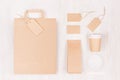 Coffee branding mockup - brown paper cup with blank bag, packet, label, cap, card, sugar on white wood board, top view. Royalty Free Stock Photo