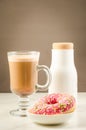 Coffee break: cappuccino, fresh sugary pink donut and white bottle/Coffee break: cappuccino, fresh sugary pink donut and white